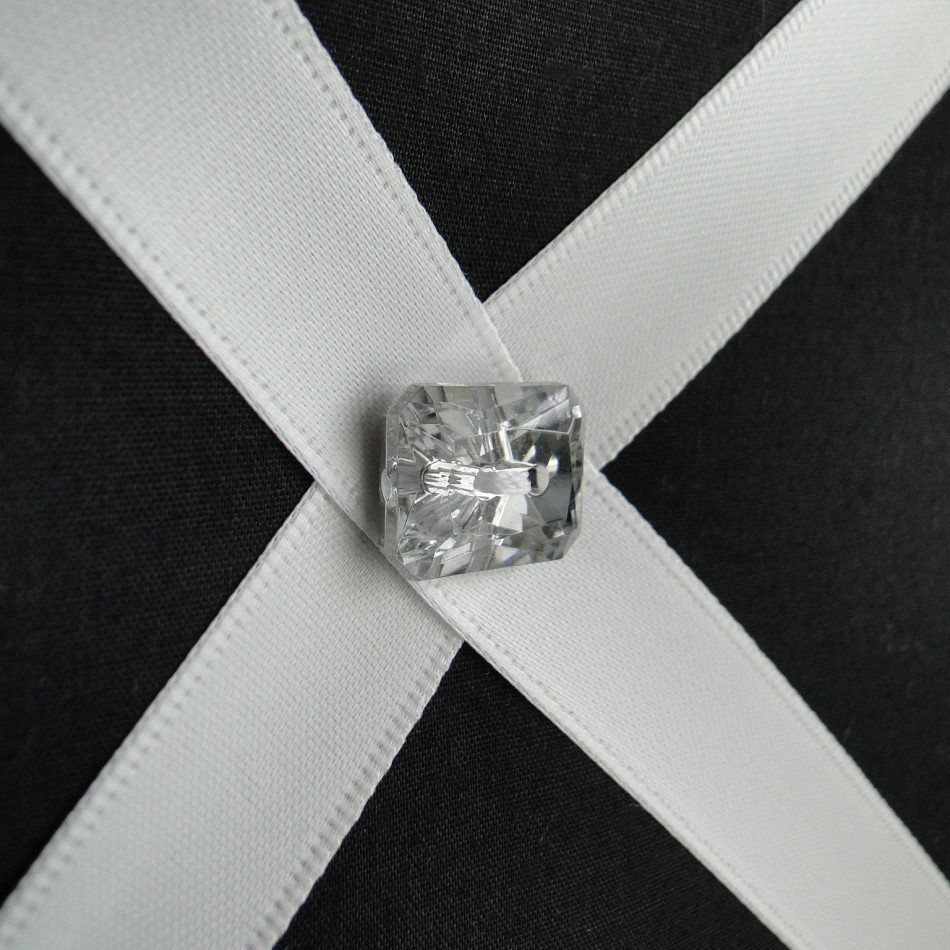 Close up of black fabric covered wall organiser with diamante button finish